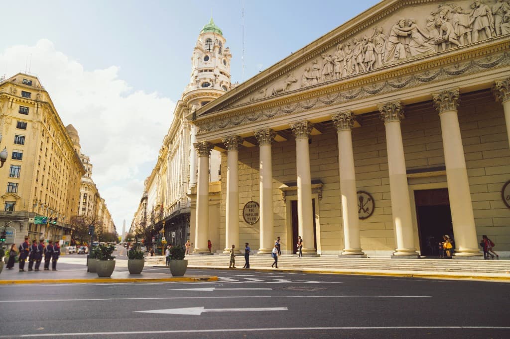 Neoclassical facade with Corinthian columns on Plaza de Mayo, Buenos Aires, daytime with people on the plaza